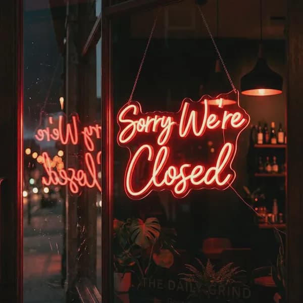 暮色中橱窗里亮着的霓虹灯「Sorry We're Closed」实拍,象征功能下线的体面告别