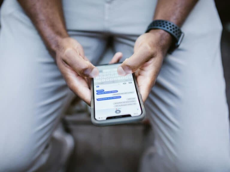 Person holding a smartphone, illustrating the hidden AI instructions found in WhatsApp help pages source code (October 2026)