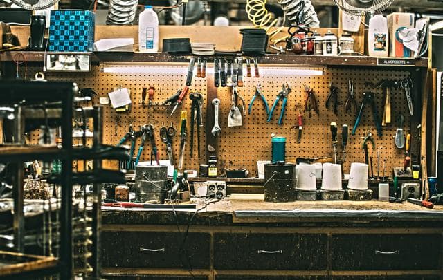 A real photograph of a workshop workbench with tools hung neatly on a pegboard, an analogy for the sorted, piece-by-piece rescue workflow.