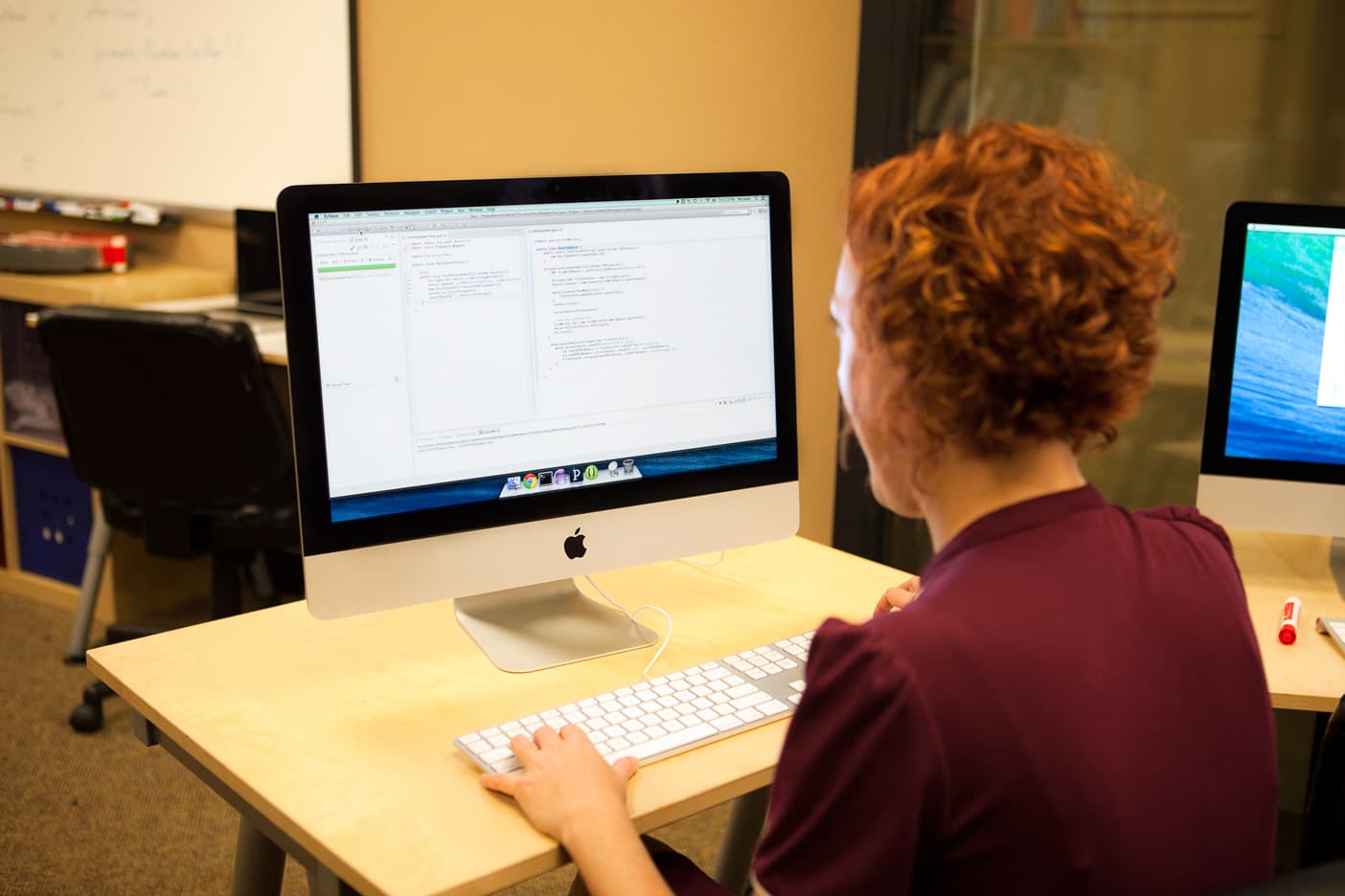 A programmer writing code with unit tests at a desk, illustrating the maintainer-review standard behind the new coding agent benchmark
