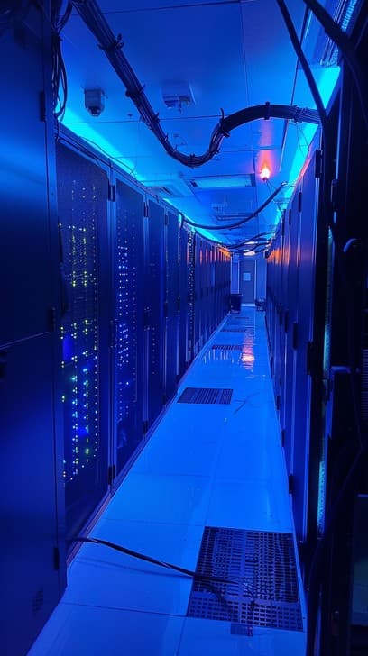 Data center server corridor under blue light, illustrating the AWS cloud security story