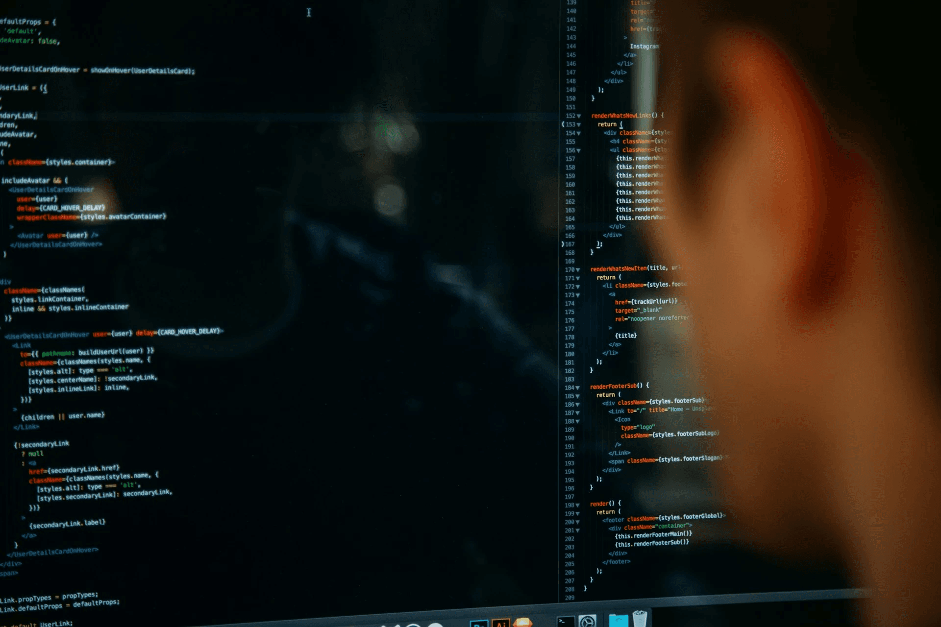 Real photo: a developer reviewing code on screen, face lit by the monitor glow