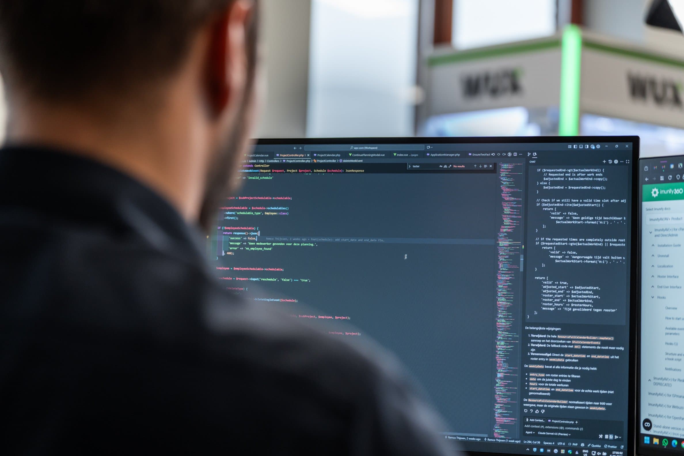 A developer seen from behind, reviewing code and an AI chat panel on screen
