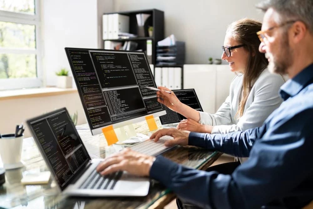 Two developers pair programming, symbolizing building AI agents inside coding environments