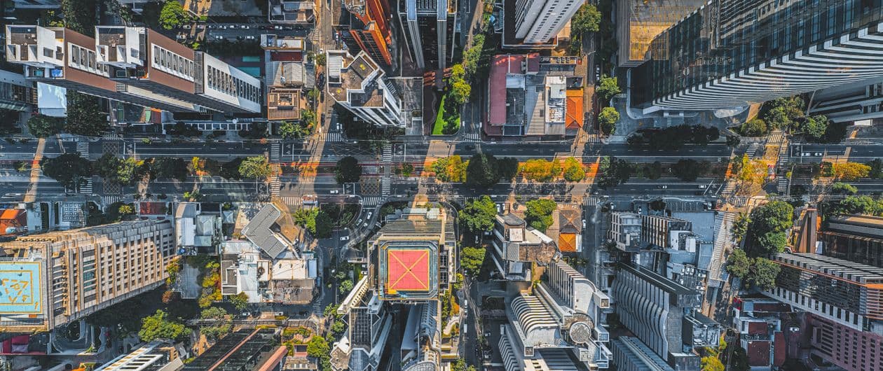 Aerial photo of a dense city with streets and high-rise buildings in warm evening light, evoking urban location services