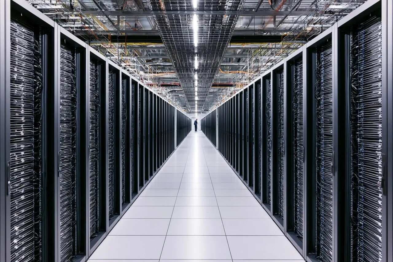 数据中心走廊里排列整齐的服务器机架(示意配图,非 OpenAI 设施)