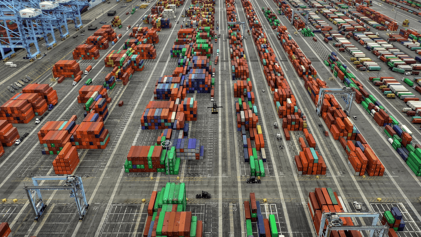 Aerial photo of a container terminal with rows of colorful shipping containers neatly stacked, a metaphor for Docker's standardized packaging