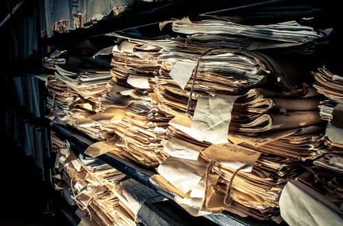 A real photo of bundled archive files on shelves, illustrating kept versions of documents over time