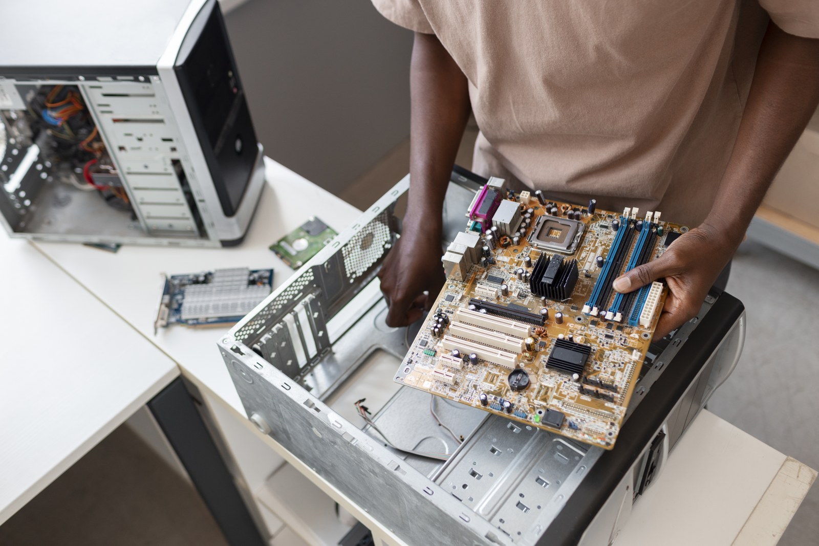 Real photo: technician installing a motherboard on a workbench