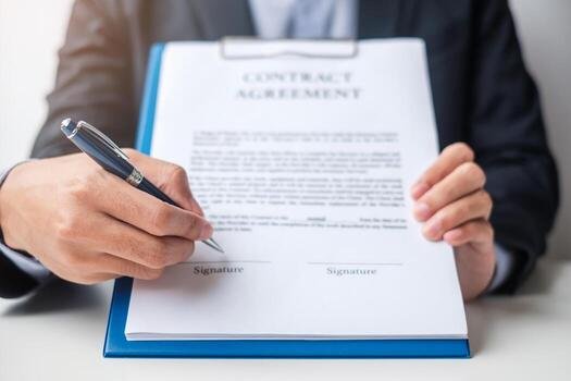 Hands holding a contract agreement with signature lines