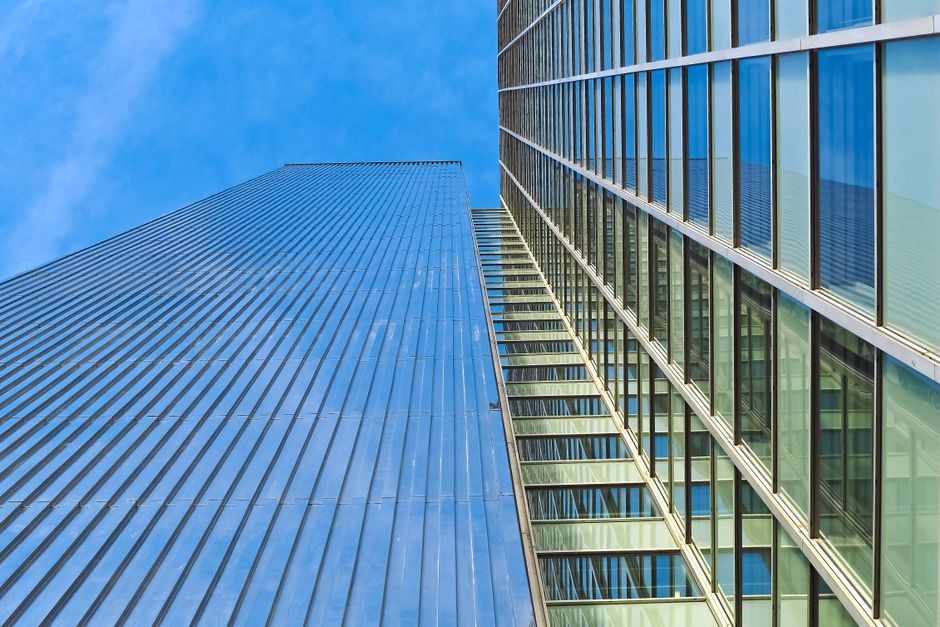 Finance-themed cover: modern bank glass facade viewed from below